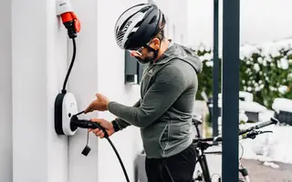 Mann schließt E-Auto-Ladekabel an eine go-e Wallbox mit CEE-Stecker an