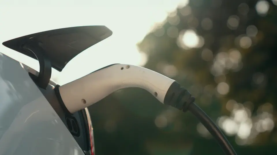 Seitenansicht eines in einem E-Auto eingesteckten Ladekabels.