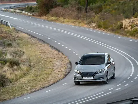 Nissan Leaf Elektroauto in der Farbe grau Ansicht von schräg Vorne während der Fahrt