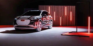 Audi Q4 etron Frontansicht in einer Präsentation. Rotes Licht scheint auf Seite des Audi q4 etron