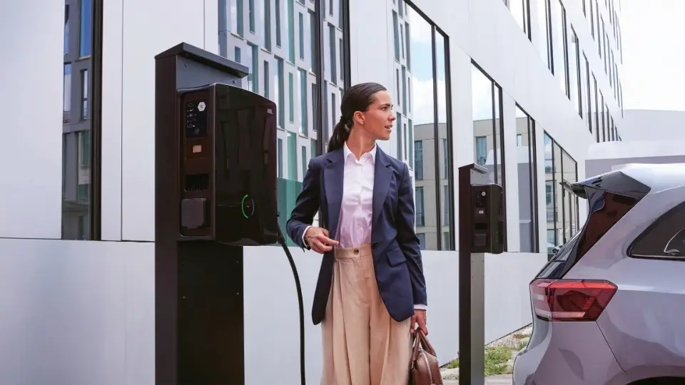 Frau an ABL eM4 Twin Wallbox auf Firmenparkplatz – Doppelladestation als VW Wallbox Alternative