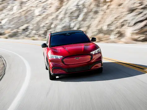 Mustang Mach-E Elektroauto in der Farbe rot Ansicht von der Seite auf einer Bergfahrt