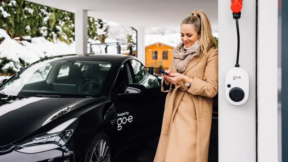 Frau steht bei Wallbox mit RFID-Funktion