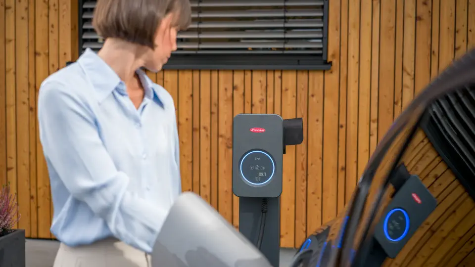 Frau lädt mit ISO-konformem Fronius Wattpilot Flex Pro