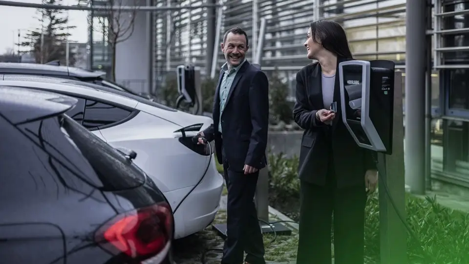 Geschäftsleute laden E-Dienstwagen: Steuerfreiheit beim Corporate Charging bleibt erhalten