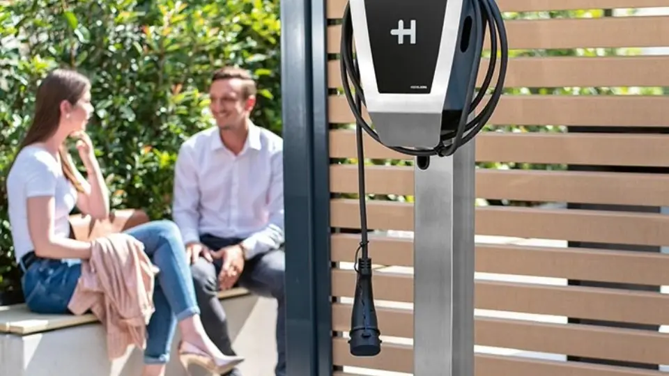 Zwei Personen unterhalten sich mit Heidelberg Wallbox Home Eco im Vordergrund
