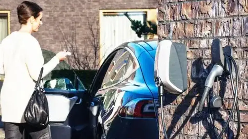 Elektroauto wird zu Hause mit Wallbox geladen - Frau nutzt Ladestation