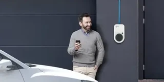 Mann steht vor Charger: Wallbox anschliessen fuer bequemes Laden