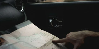 Finger auf Landkarte im E-Auto