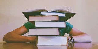 Mensch hinter Bücherstapel