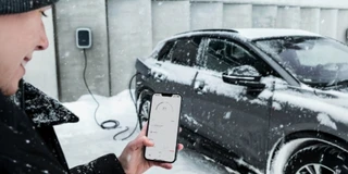 Mann steuert Audi Wallbox im Winter per Smartphone-App