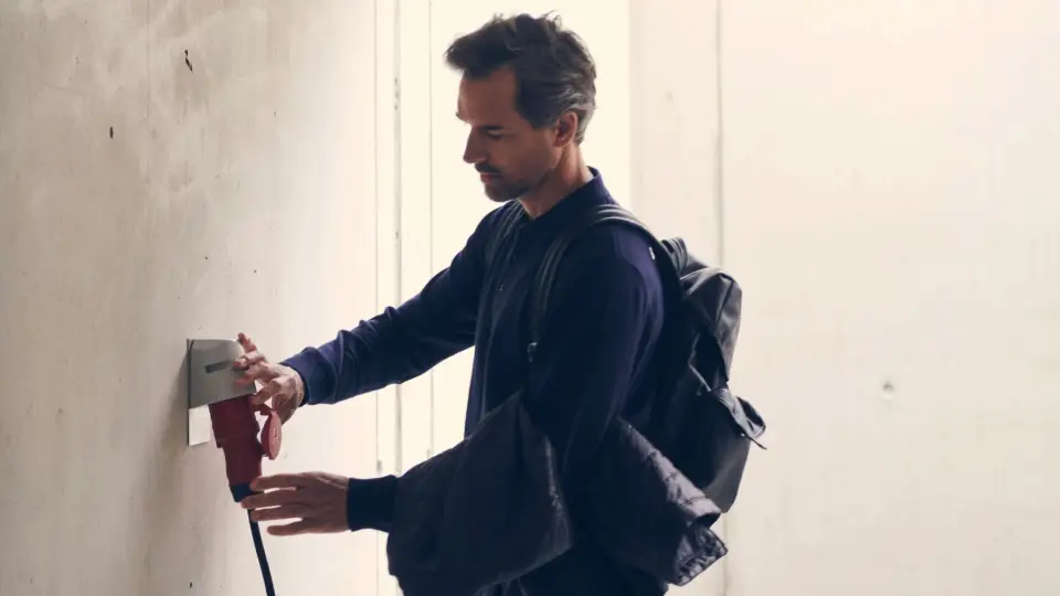 Mann steckt angemeldete mobile Wallbox an seiner CEE Steckdose an