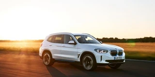 Ansicht BMW iX3 in Weiss mit Akzenten von schräg Vorne mit Sonnenuntergang