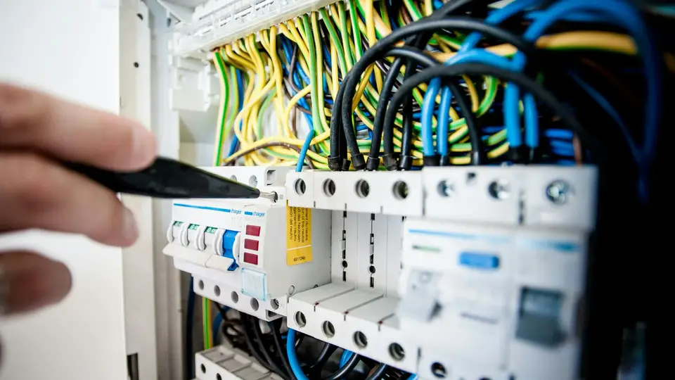 Elektriker arbeitet am Stromkasten.