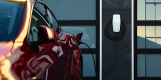 Tesla Wallbox lädt rotes Fahrzeug vor Garage
