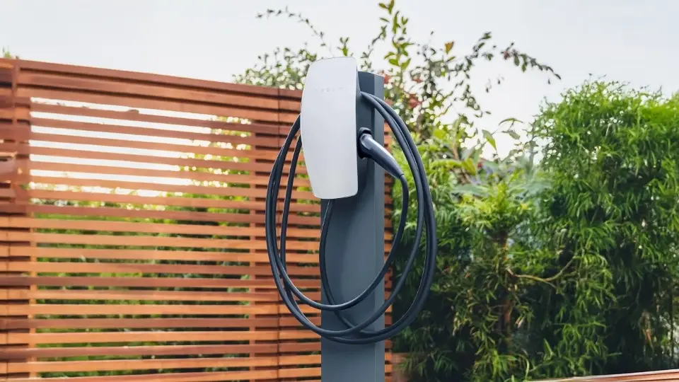 Tesla Wallbox im Außenbereich installiert, montiert auf Stele mit Ladekabel