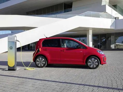 VW e-Up Elektroauto in der Farbe rot Ansicht von der Seite beim Laden an einer Ladesäule