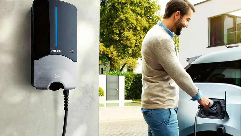 Kosten für Wallbox-Installation zuhause - Mann lädt E-Auto mit moderner Ladestation
