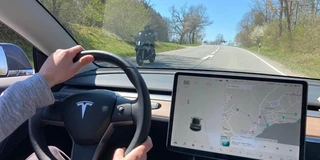 Innenaufnahme im Tesla Model 3. Bildschirm und Lenkrad von Tesla sind zu sehen.