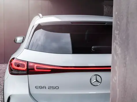 Mercedes Benz EQA weiss Heckansicht hinter Mauer