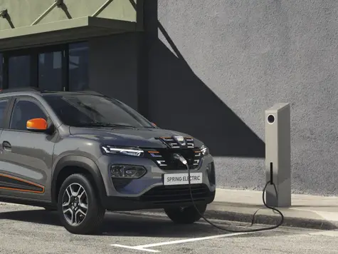 Dacia Spring Electric in der Farbe grau Ansicht Front beim Laden an einer Ladesäule