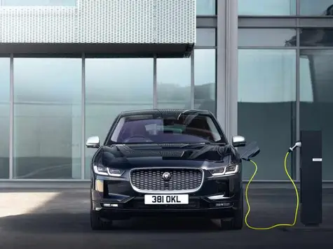 Jaguar I-Pace Elektroauto in der Farbe Schwarz Ansicht beim Laden an der Ladesäule mit Ladekabel