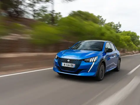 Peugeot e-208 Elektroauto in der Farbe blau Ansicht von schräg Vorne während der Fahrt