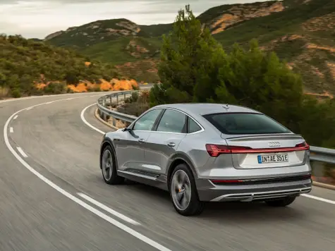 Audi e-tron Sportback Elektroauto in der Farbe Silber Ansicht von schräg Hinten in der Fahrt