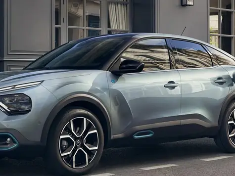 Citroën ë-C4 Elektroauto in der Farbe türkis Ansicht von der Seite an einer Ladestation beim Laden